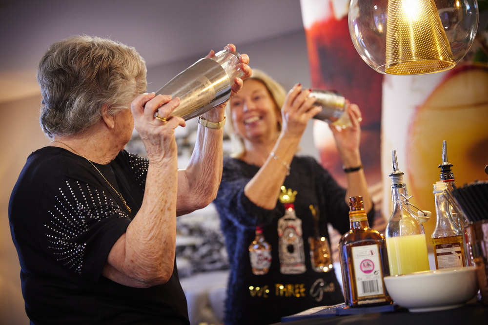 Two ladies making cocktails